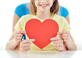 Image showing close up of girl and mother holding red heart