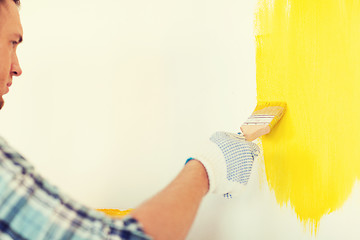 Image showing close up of male in gloves holding paintbrush