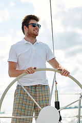 Image showing young man in sunglasses steering wheel on yacht