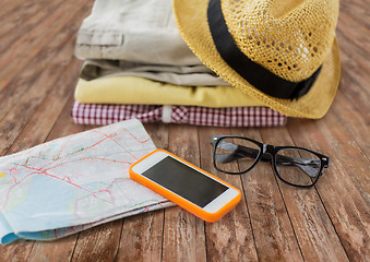 Image showing close up of summer clothes and travel map on floor