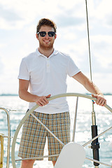 Image showing young man in sunglasses steering wheel on yacht