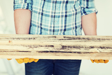 Image showing close up of male in gloves carrying wooden boards