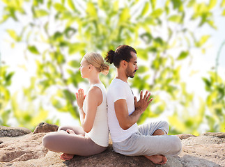 Image showing smiling couple making yoga exercises outdoors