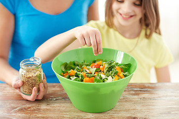 Image showing close up of happy family cooking salad in kitchen