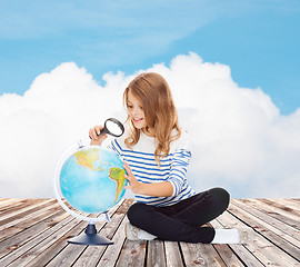 Image showing happy girl looking at globe with magnifier