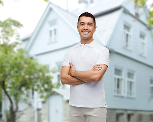 Image showing smiling man in white t-shirt over house background