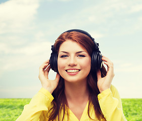 Image showing smiling young girl in headphones at home