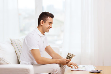 Image showing man with papers and calculator at home