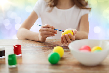 Image showing close up of girl with brush coloring easter eggs