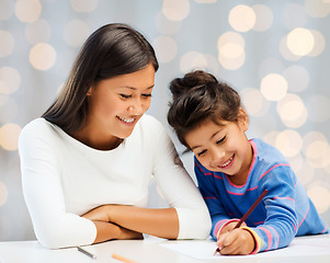 Image showing happy mother and daughter drawing with pencils