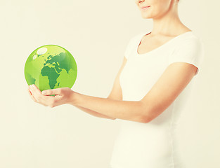 Image showing woman holding green sphere globe