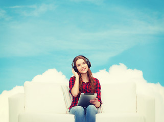 Image showing girl sitting on sofa with headphones and tablet pc