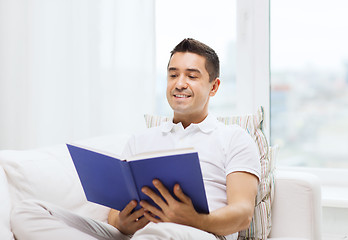 Image showing happy man reading book at home