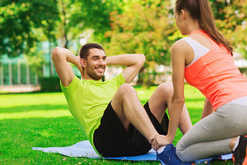 Image showing smiling man doing exercises on mat outdoors