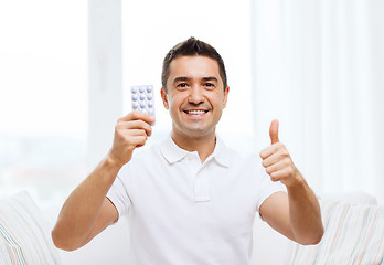 Image showing happy man with pack of pills showing thumbs up