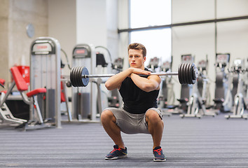 Image showing young man flexing muscles with barbell in gym