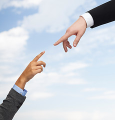 Image showing close up of woman and man hands trying to connect