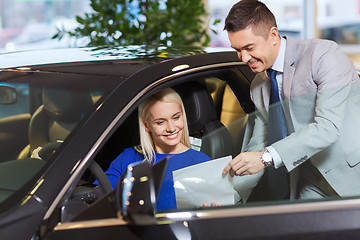 Image showing happy woman with car dealer in auto show or salon