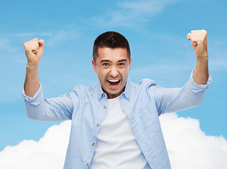 Image showing happy laughing man with raised hands