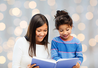 Image showing happy mother and little daughter reading book