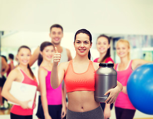 Image showing teenage girl with jar of protein showing thumbs up