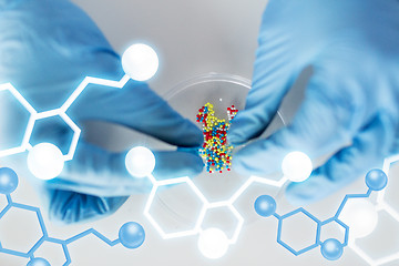 Image showing close up of scientist hands holding pill in lab