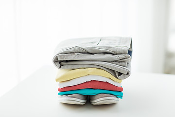 Image showing close up of folded shirts and boots on table