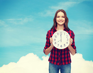 Image showing young woman in casual clothes with wall clock