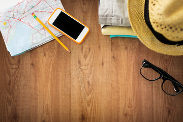 Image showing close up of summer clothes and travel map on table