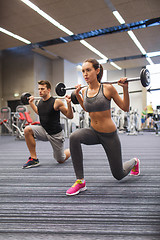 Image showing young man and woman training with barbell in gym