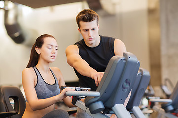 Image showing woman with trainer on exercise bike in gym