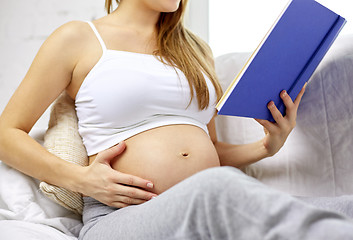 Image showing close up of pregnant woman reading book at home