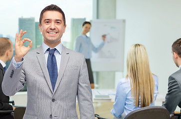 Image showing happy businessman in suit showing ok hand sign