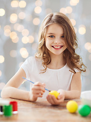 Image showing close up of girl with brush coloring easter eggs