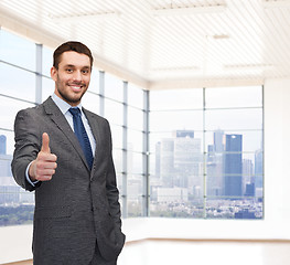 Image showing happy young businessman showing thumbs up