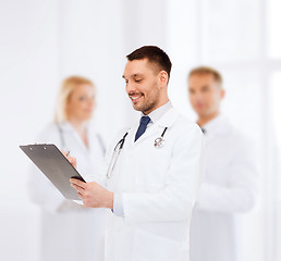 Image showing smiling male doctor with clipboard and stethoscope