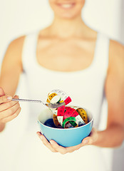 Image showing woman hands holding bowl with measuring tape