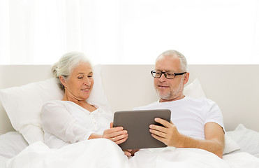 Image showing happy senior couple with tablet pc at home