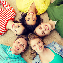 Image showing group of smiling people lying down on floor