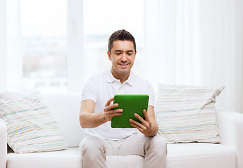 Image showing smiling man working with tablet pc at home