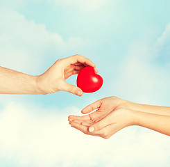 Image showing man hand giving red heart to woman