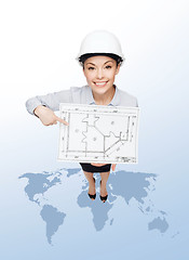 Image showing businesswoman in helmet showing with blueprint