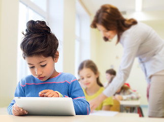 Image showing little school girl with tablet pc over classroom