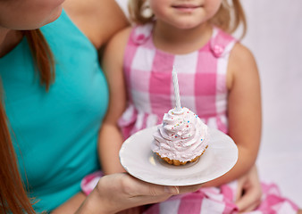 Image showing happy mother and little girl holding cupcake