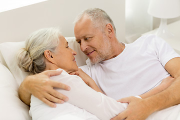 Image showing happy senior coupler lying in bad at home