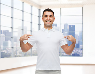 Image showing smiling man in t-shirt pointing fingers on himself