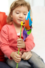 Image showing happy little girl with mother holding pinwheel toy