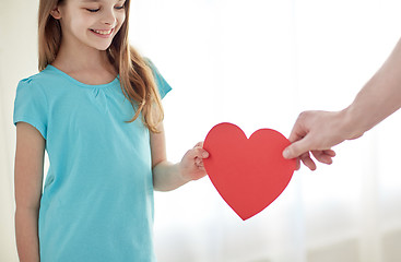 Image showing close up of girl and male hand holding red heart