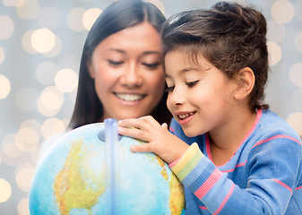 Image showing happy mother and daughter with globe