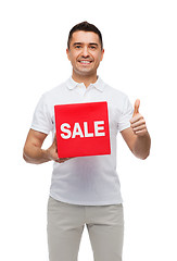 Image showing smiling man with red sale sigh showing thumbs up